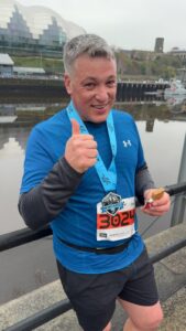 Man in running kit with a thumbs up. 
