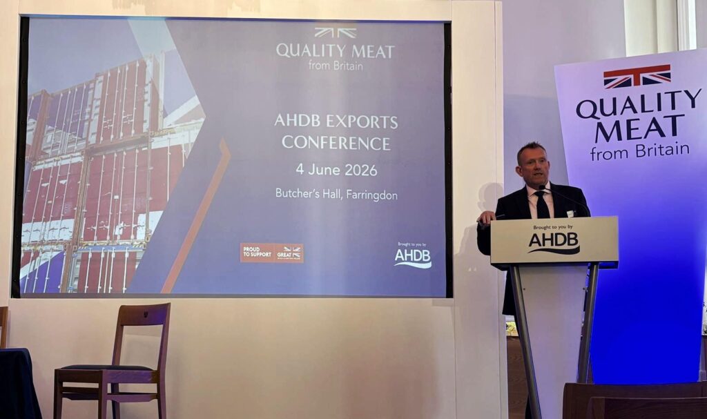 Man presenting at a conference next to presentation
