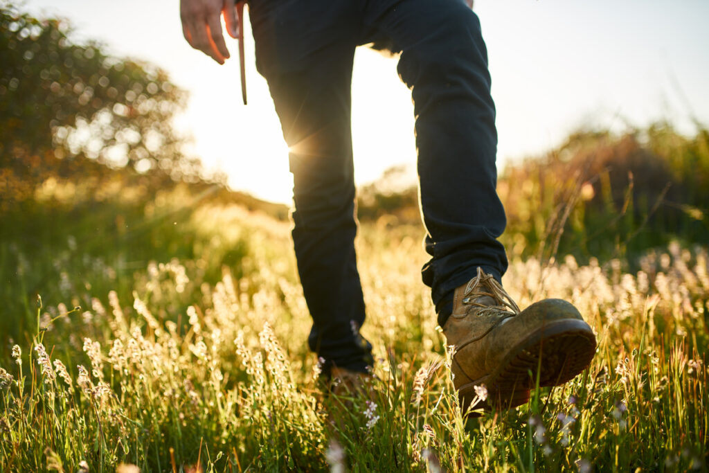Man with boots walking through a field